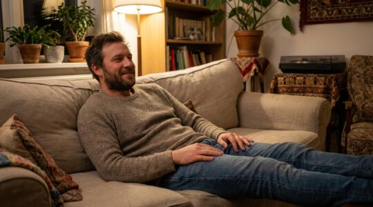 Homme détendu dans son salon en soirée, moment de relaxation naturelle
